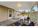 A relaxing covered patio features stylish seating and a view of the fenced backyard at 8736 W 46Th Ave, Wheat Ridge, CO 80033