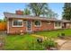 Charming single-story brick home featuring a well-manicured lawn and landscaped garden beds, creating a welcoming curb appeal at 8736 W 46Th Ave, Wheat Ridge, CO 80033