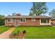 Beautiful brick home with a well-maintained lawn, mature trees, and charming landscaping, offering a welcoming curb appeal at 8736 W 46Th Ave, Wheat Ridge, CO 80033
