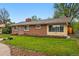 Lovely home with a well-kept lawn, mature trees, and brick accents, creating a charming and inviting facade at 8736 W 46Th Ave, Wheat Ridge, CO 80033