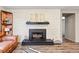 Cozy living room featuring a fireplace, brick accent wall, and hardwood floors, creating a warm and inviting space at 8736 W 46Th Ave, Wheat Ridge, CO 80033