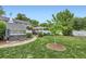 Landscaped backyard with hot tub, patio, dining set, privacy fence, and mature trees at 1000 N Monaco Pkwy, Denver, CO 80220