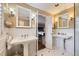 Bright bathroom featuring double sinks, wainscoting, and tile flooring at 1000 N Monaco Pkwy, Denver, CO 80220
