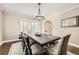 Bright dining room boasting a large window and an elegant modern light fixture above the dark wood dining table at 1000 N Monaco Pkwy, Denver, CO 80220