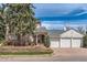 Charming brick home with a three-car garage, mature trees, and a retaining wall at 1000 N Monaco Pkwy, Denver, CO 80220