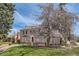 Charming brick home with mature trees, a retaining wall, and a well-manicured lawn at 1000 N Monaco Pkwy, Denver, CO 80220