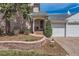Charming brick home with a three-car garage, mature trees, and a retaining wall at 1000 N Monaco Pkwy, Denver, CO 80220