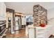 Modern kitchen featuring stainless steel appliances, white cabinets, brick accent wall, with island for cooking and entertaining at 1000 N Monaco Pkwy, Denver, CO 80220