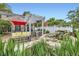 A patio with a stone waterfall, dining area with a red umbrella, and pergola-covered seating area at 1000 N Monaco Pkwy, Denver, CO 80220