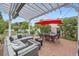 Brick patio with a pergola, outdoor seating, and well-manicured landscaping at 1000 N Monaco Pkwy, Denver, CO 80220