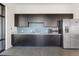 Modern kitchenette features sleek dark cabinets, stainless steel appliances, and eye-catching backsplash at 8475 E 36Th Ave # 131, Denver, CO 80238