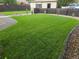 Expansive backyard featuring a lush green lawn, complemented by decorative stone accents and fencing at 3540 Niagara St, Denver, CO 80207