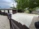 Detached garage with a dark brown door, expansive driveway, and fenced rock garden at 3540 Niagara St, Denver, CO 80207