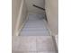 Basement staircase with tiled landing leading to painted steps, offering a modern design at 3540 Niagara St, Denver, CO 80207