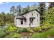 View of home showing vibrant landscaping and outdoor charm at 5071 Parmalee Gulch Rd, Indian Hills, CO 80454