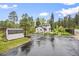 Charming two-story home with a wet black asphalt driveway and lush natural landscaping at 5071 Parmalee Gulch Rd, Indian Hills, CO 80454