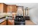 Well-lit kitchen showcasing cabinetry, range, and wood flooring at 5071 Parmalee Gulch Rd, Indian Hills, CO 80454