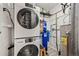 Efficient laundry room with stackable washer and dryer and wall-mounted filtration system at 5071 Parmalee Gulch Rd, Indian Hills, CO 80454