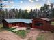Aerial view of home featuring wood siding, a green metal roof, and an oversized garage at 9123 Booker Ln, Conifer, CO 80433