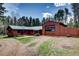 Exterior view of a wood-sided home with a metal roof, complemented by a large garage at 9123 Booker Ln, Conifer, CO 80433