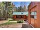 Charming home featuring wood siding, a durable green metal roof, and an attached garage at 9123 Booker Ln, Conifer, CO 80433