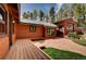 Exterior view of home with wood siding, green metal roof, patio, and oversized garage at 9123 Booker Ln, Conifer, CO 80433
