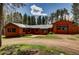 Exterior view of home featuring wood siding, a green metal roof and an oversized garage at 9123 Booker Ln, Conifer, CO 80433