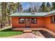 Close up of home featuring wood siding, a green metal roof, and a front door entrance at 9123 Booker Ln, Conifer, CO 80433
