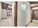 Hallway with light gray walls, wood trim and view into bedroom with carpet at 9123 Booker Ln, Conifer, CO 80433