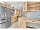 Open kitchen with wood cabinets, stainless steel refrigerator, and a functional workstation at 9123 Booker Ln, Conifer, CO 80433