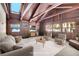 Inviting living room boasts exposed wood beams, many windows, and ample natural light at 9123 Booker Ln, Conifer, CO 80433