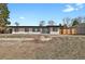 Charming home features a backyard with an unfinished landscape and wooden fence at 9950 W 17Th Ave, Lakewood, CO 80215