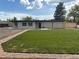 Modern home showcasing a well-manicured lawn and neutral exterior against a backdrop of a partly cloudy sky at 9950 W 17Th Ave, Lakewood, CO 80215