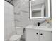 Modern bathroom featuring marble-style tile, a lighted mirror, and a contemporary vanity at 9950 W 17Th Ave, Lakewood, CO 80215