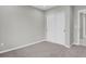 Bedroom with carpet and gray walls, featuring double-door closet and view into hallway at 9950 W 17Th Ave, Lakewood, CO 80215