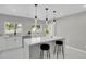 Stylish kitchen island features a quartz countertop, pendant lighting, and modern bar stools at 9950 W 17Th Ave, Lakewood, CO 80215