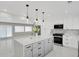 Modern white kitchen with island, stainless steel appliances, and pendant lighting at 9950 W 17Th Ave, Lakewood, CO 80215