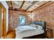 Cozy bedroom with exposed brick walls, hardwood floors, and a comfortable bed with a modern design at 1465 S Pearl St # 6, Denver, CO 80210