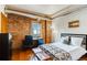 Bedroom with exposed brick, hardwood floors, and a workspace near the window at 1465 S Pearl St # 6, Denver, CO 80210