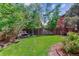 Secluded backyard featuring a lush lawn, mature trees, privacy fence, and wooden bench perfect for relaxing at 5373 E Links Cir, Centennial, CO 80122