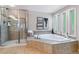 Bright bathroom featuring a modern shower and luxurious soaking tub under window at 5373 E Links Cir, Centennial, CO 80122