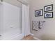 Neat bathtub-shower combination featuring neutral walls, tiled floors, and unique picture frames at 5373 E Links Cir, Centennial, CO 80122