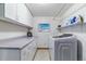 Functional laundry room with ample counter space, modern washer and dryer, and shelving for storage at 5373 E Links Cir, Centennial, CO 80122