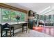 Living area with dry bar, large windows offering backyard views, and adjacent seating area at 5373 E Links Cir, Centennial, CO 80122