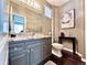 Stylish half bath featuring custom vanity with granite countertops, modern fixtures, and a decorative mirror at 6561 Ocaso Dr, Castle Pines, CO 80108