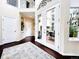 Bright foyer featuring hardwood floors, a decorative rug, and access to an outdoor patio through glass doors at 6561 Ocaso Dr, Castle Pines, CO 80108