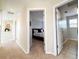 Hallway view showing neutral walls and carpet with entry to bedroom and bathroom at 6561 Ocaso Dr, Castle Pines, CO 80108