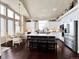 Bright eat-in kitchen featuring a granite island, stainless appliances, and modern white cabinetry at 6561 Ocaso Dr, Castle Pines, CO 80108