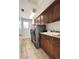 Spacious laundry room features cabinetry, sink, neutral tile floors and front load washer and dryer at 6561 Ocaso Dr, Castle Pines, CO 80108