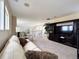 Upstairs living room featuring a large TV, a comfortable sofa, and an open view of the downstairs area at 6561 Ocaso Dr, Castle Pines, CO 80108